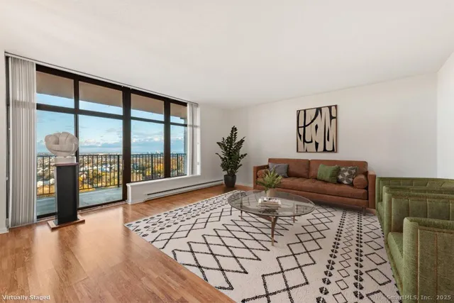 a living room with furniture and a floor to ceiling window