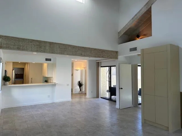a view of a big room with wooden floor and windows