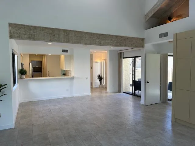 a view of a big room with wooden floor and a kitchen view