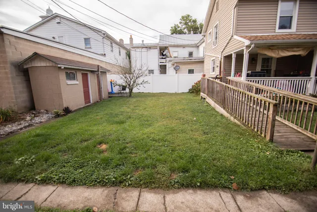 a view of a house with a small yard and wooden fence