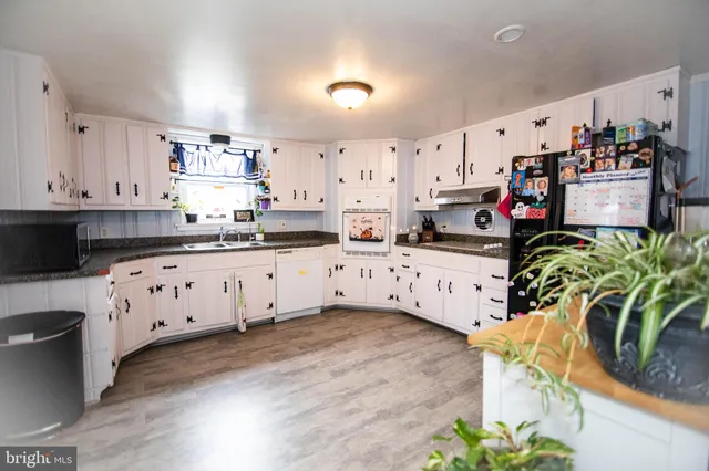 a kitchen with stainless steel appliances a stove a sink and a white cabinets