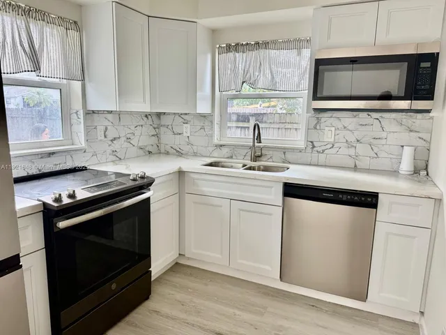 a kitchen with a stove microwave and sink
