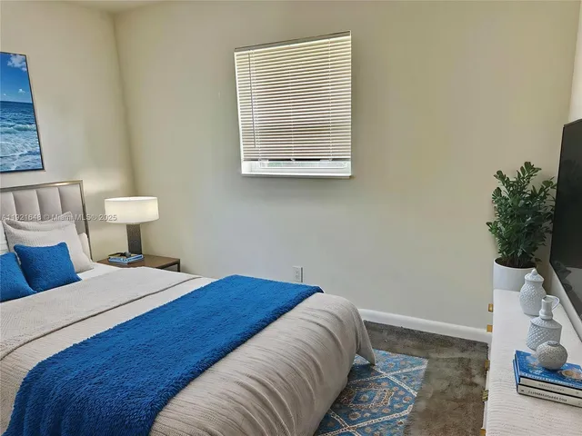 a bedroom with a bed and a potted plant