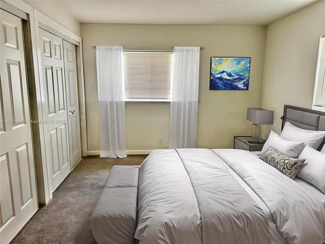 a bedroom with a bed and painting on the wall