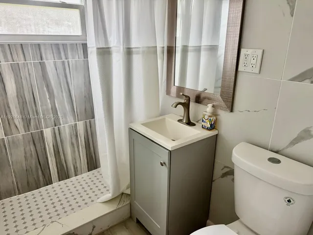 a bathroom with a sink toilet and window