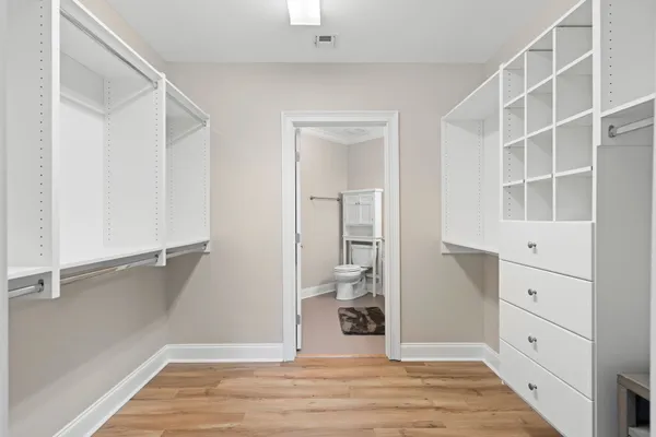 a view of walk in closet with empty racks
