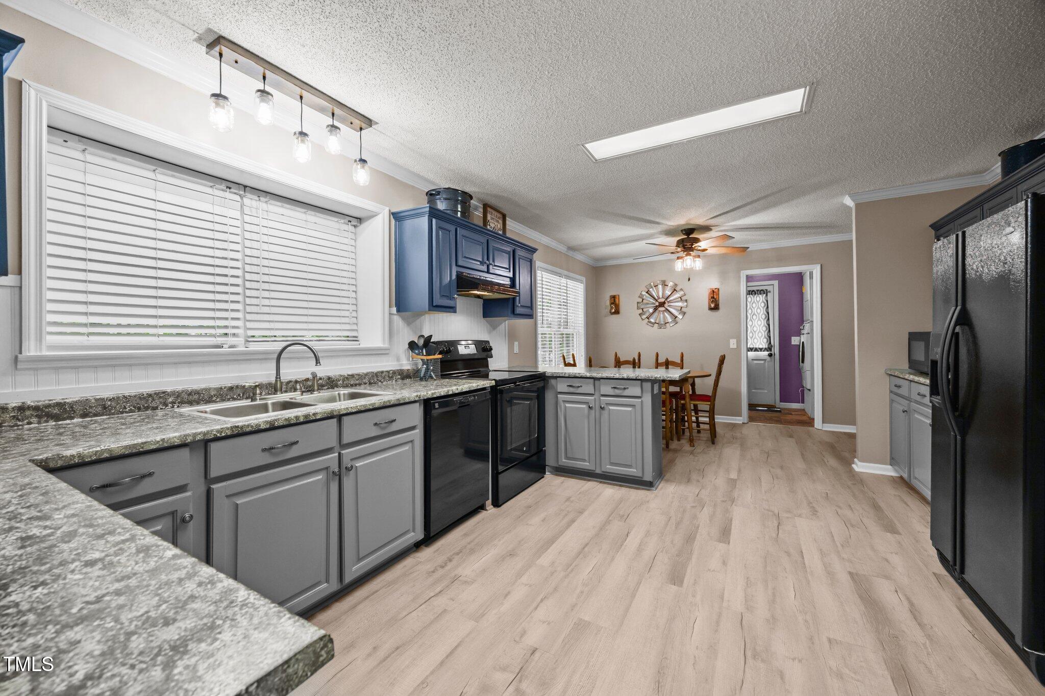 117 Lema Drive Garner, NC 27529 - Photo 11 of 34 a kitchen with stainless steel appliances kitchen island granite countertop a sink cabinets and wooden floor