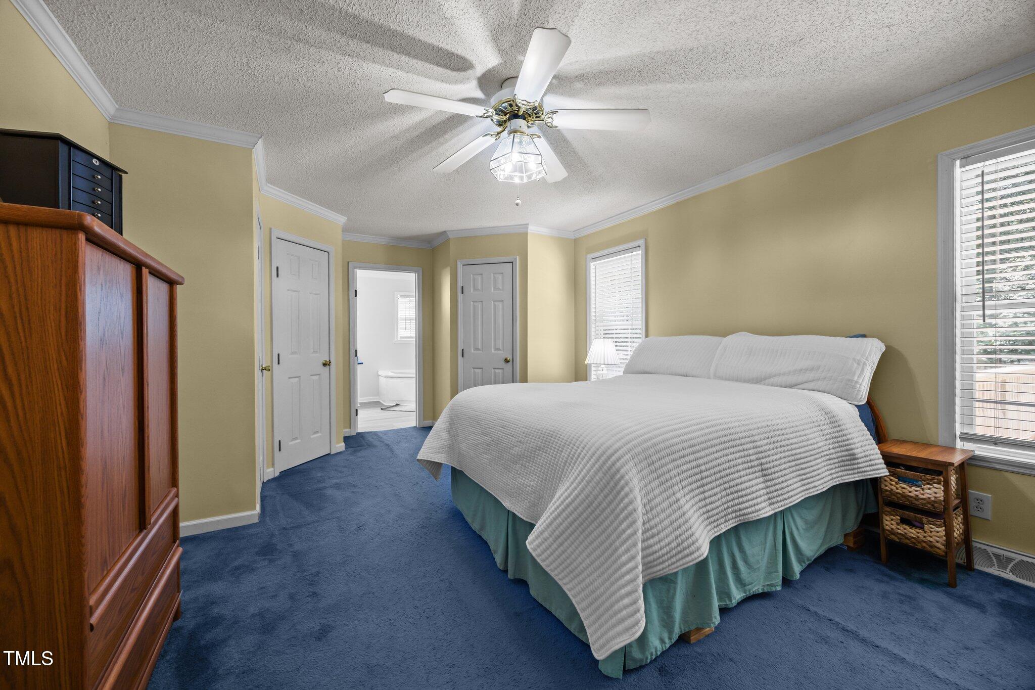 117 Lema Drive Garner, NC 27529 - Photo 18 of 34 a spacious bedroom with a bed and a chandelier