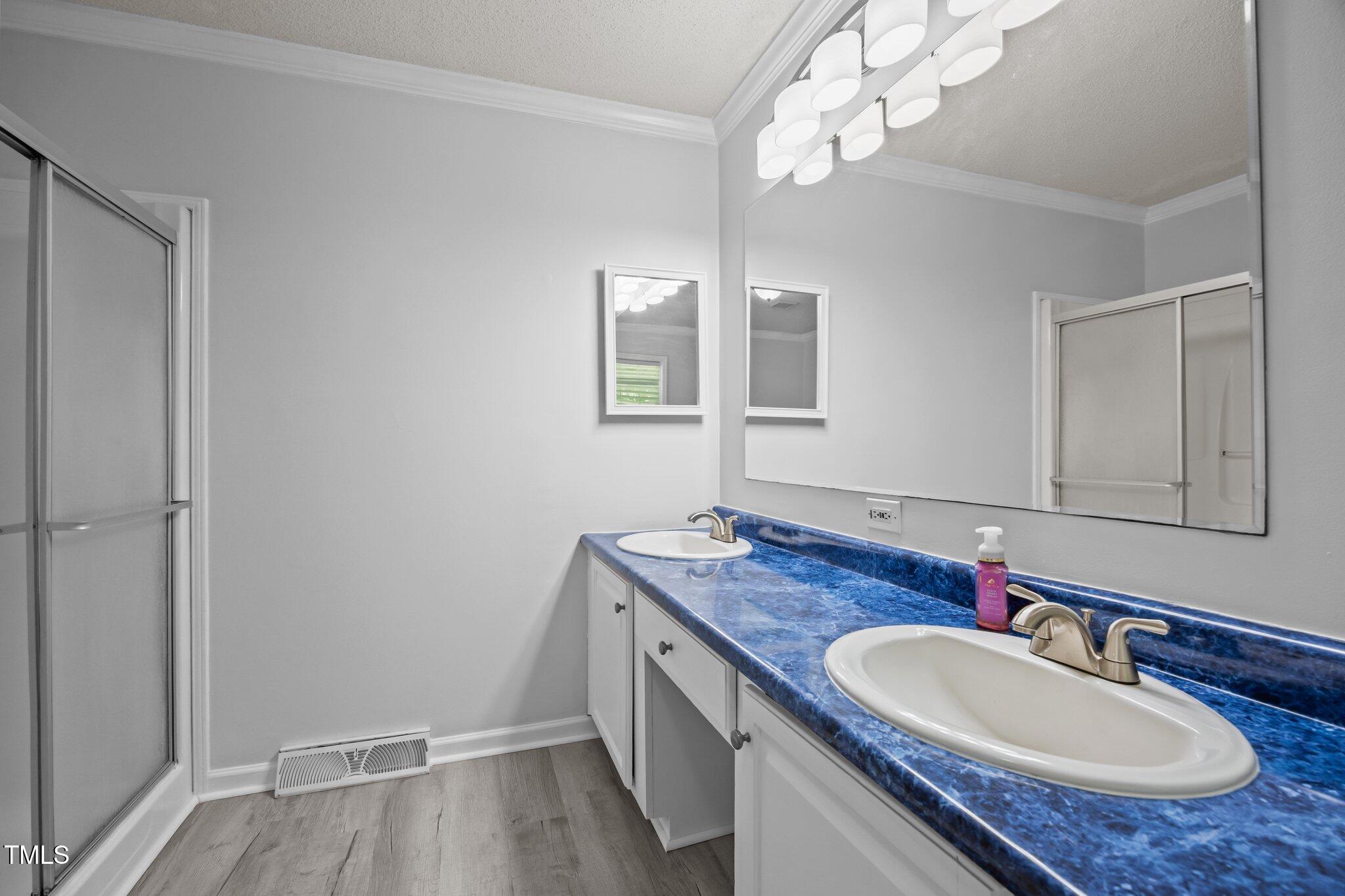 117 Lema Drive Garner, NC 27529 - Photo 21 of 34 a bathroom with a granite countertop double vanity and a mirror