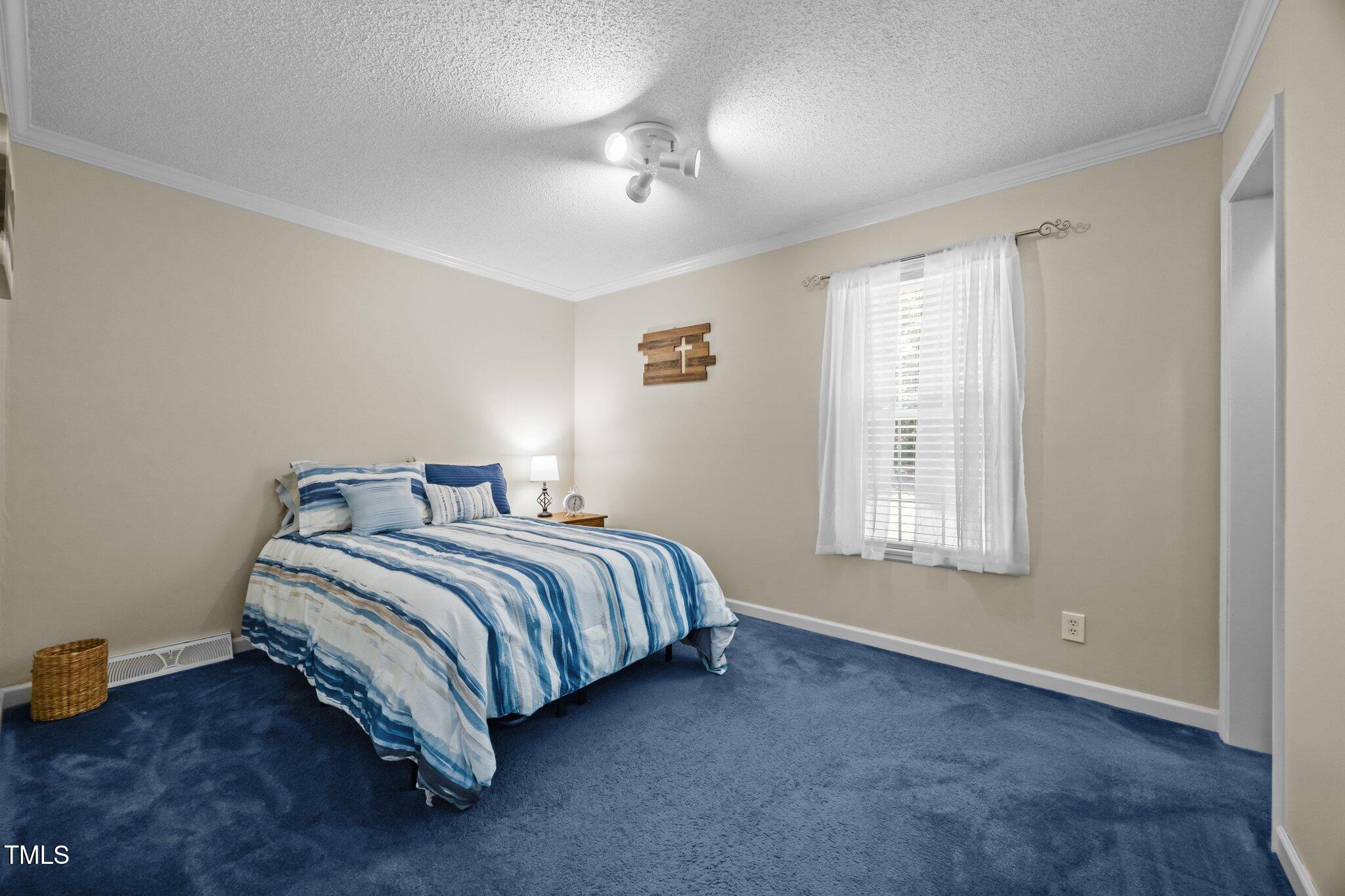 117 Lema Drive Garner, NC 27529 - Photo 23 of 34 a spacious bedroom with a bed and a window