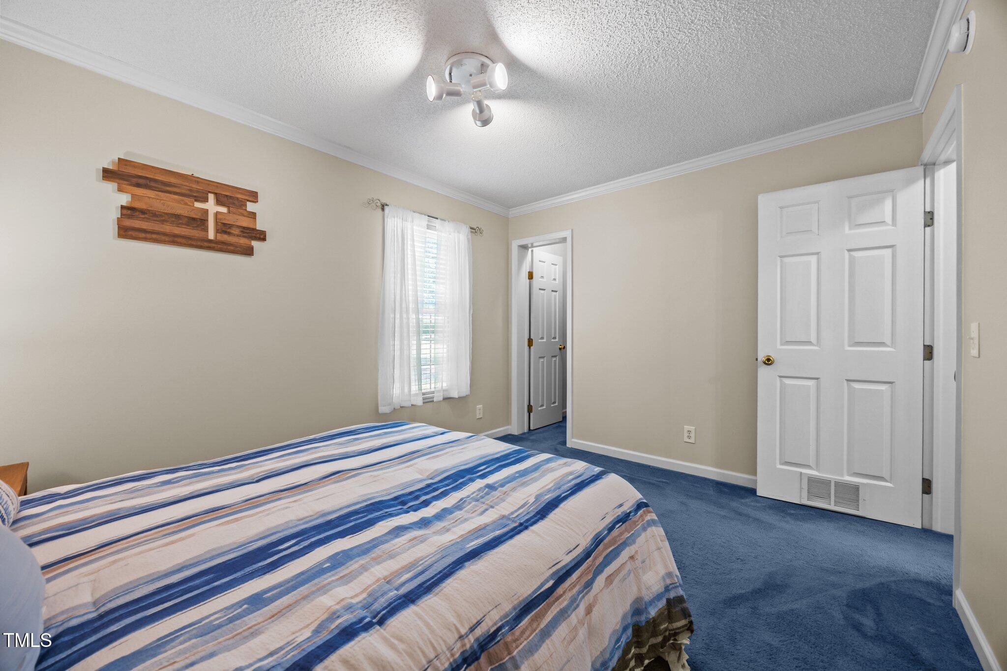 117 Lema Drive Garner, NC 27529 - Photo 24 of 34 a bedroom with a bed and a chandelier