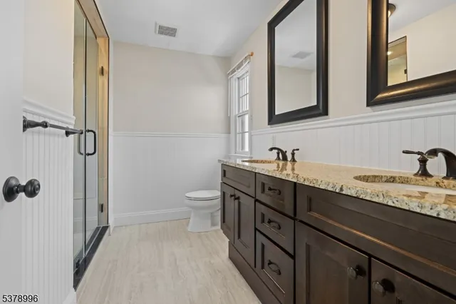 a spacious bathroom with a granite countertop sink toilet and shower