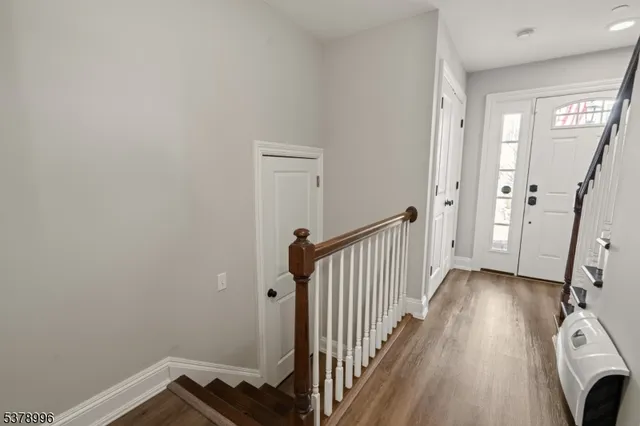 a view of a hallway with wooden floor and staircase