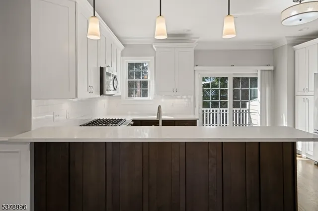 a view of a kitchen that has a lot of cabinets and wooden floor