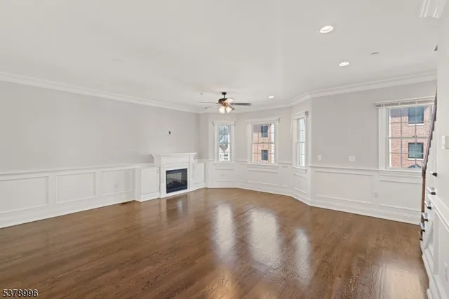 a view of empty room with wooden floor and fireplace