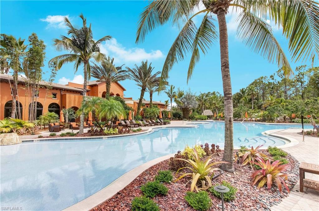 9076 Rialto Street, Unit 6204 Naples, FL 34113 - Photo 44 of 50 Resort-style pool with integrated steps, surrounded by mature palm trees and tropical landscaping is located steps away from the condo unit.