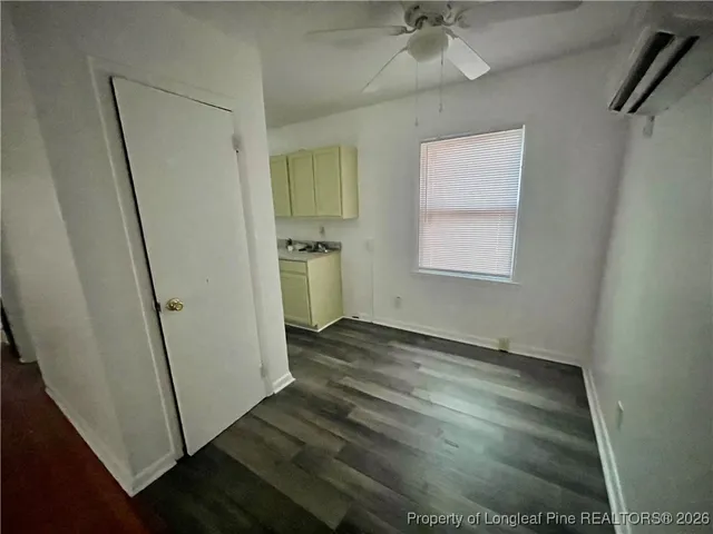 an empty room with wooden floor and a ceiling fan