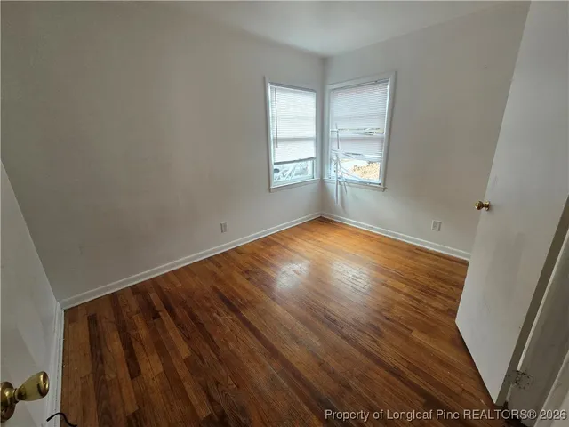 a view of empty room with wooden floor