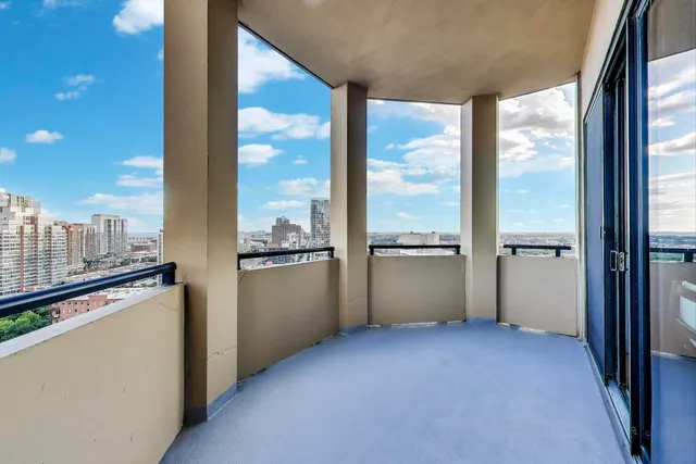 a view of a kitchen with a refrigerator and white cabinets