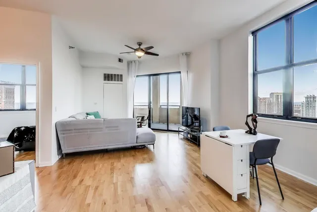 a living room with furniture and a wooden floor