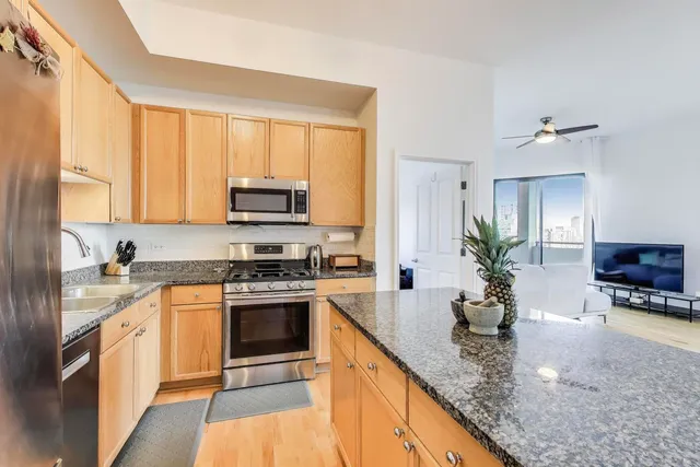 a kitchen with stainless steel appliances granite countertop a stove a sink and a microwave
