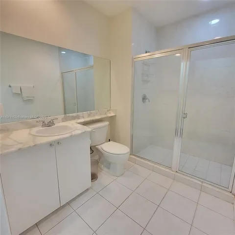 a bathroom with a shower sink vanity and toilet