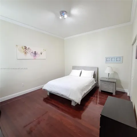 a bedroom with a bed and a lamp on dresser