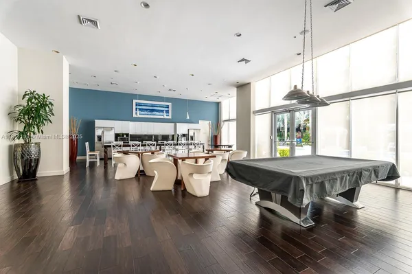 a room with wooden floor table and chairs