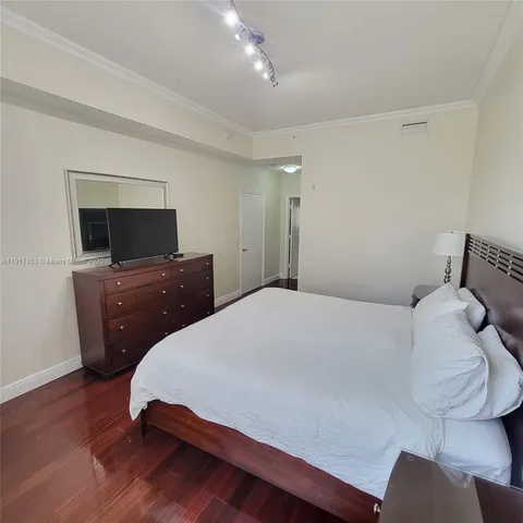 a bedroom with a bed and a flat screen tv