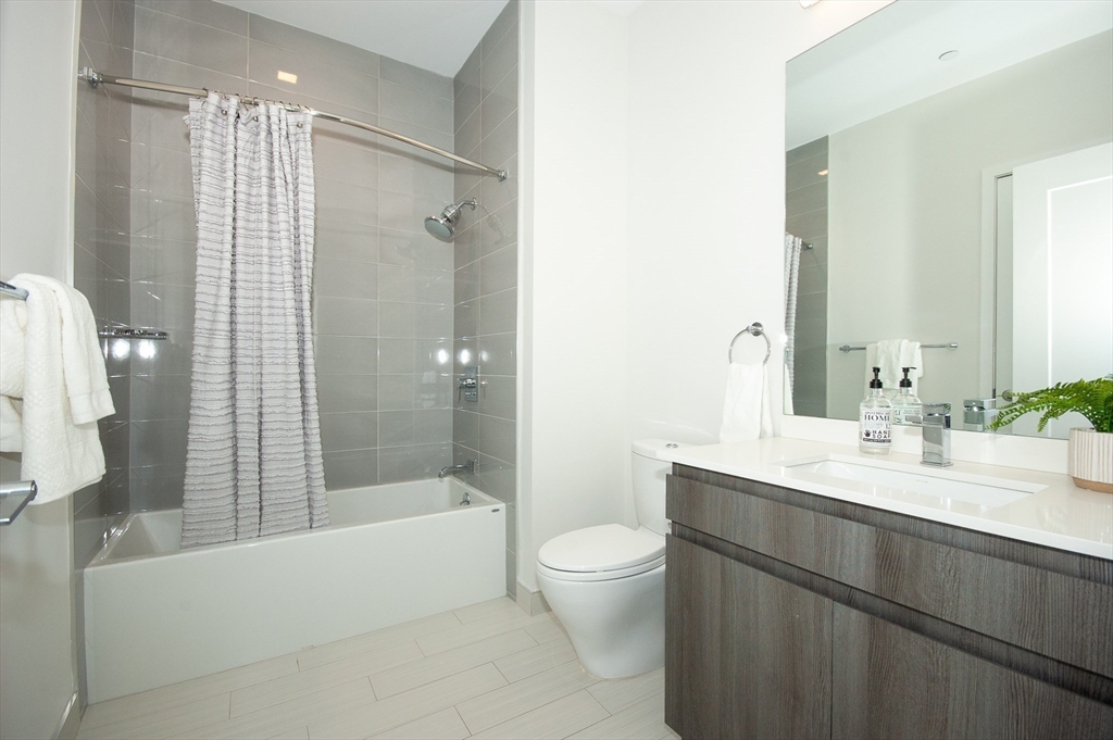 45 West 3rd Street, Unit 409 Boston, MA 02127 - Photo 20 of 30 a bathroom with a bathtub shower sink mirror and toilet