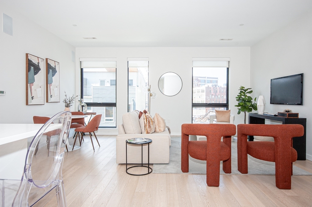 45 West 3rd Street, Unit 409 Boston, MA 02127 - Photo 3 of 30 a living room with furniture a flat screen tv and a large window
