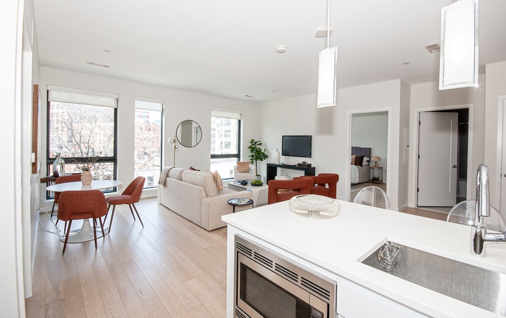 45 West 3rd Street, Unit 409 Boston, MA 02127 - Photo 5 of 30 a living room with furniture a fireplace and a large window