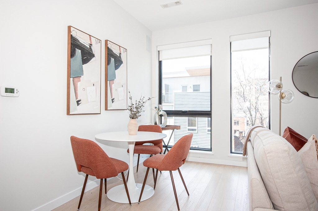 45 West 3rd Street, Unit 409 Boston, MA 02127 - Photo 7 of 30 a view of a dining room with furniture and wooden floor