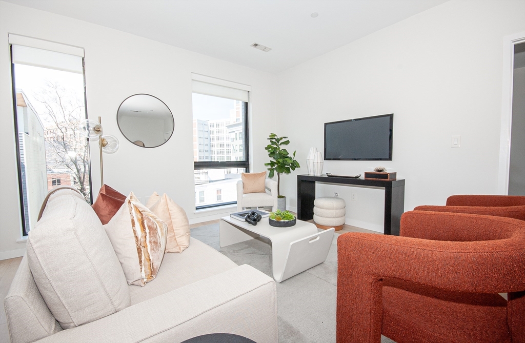 45 West 3rd Street, Unit 409 Boston, MA 02127 - Photo 9 of 30 a living room with furniture a flat screen tv and a window