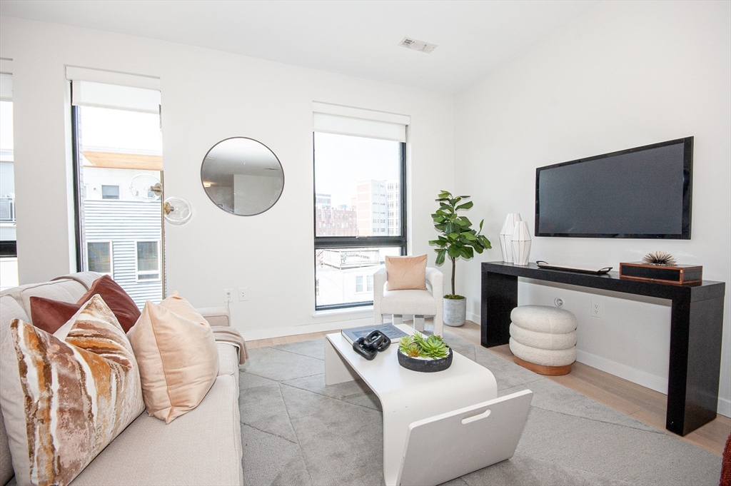45 West 3rd Street, Unit 409 Boston, MA 02127 - Photo 10 of 30 a living room with furniture and a flat screen tv