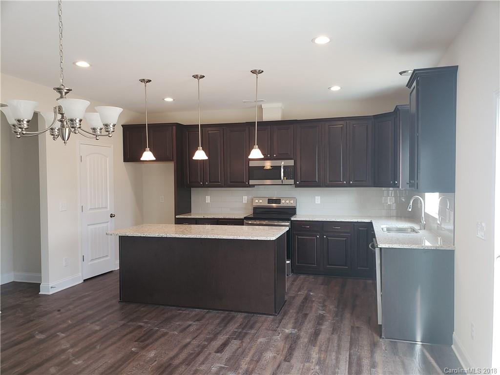 4220 Sincerity Road, Unit 4 Monroe, NC 28110 - Photo 2 of 23 a kitchen with kitchen island a sink stainless steel appliances and cabinets