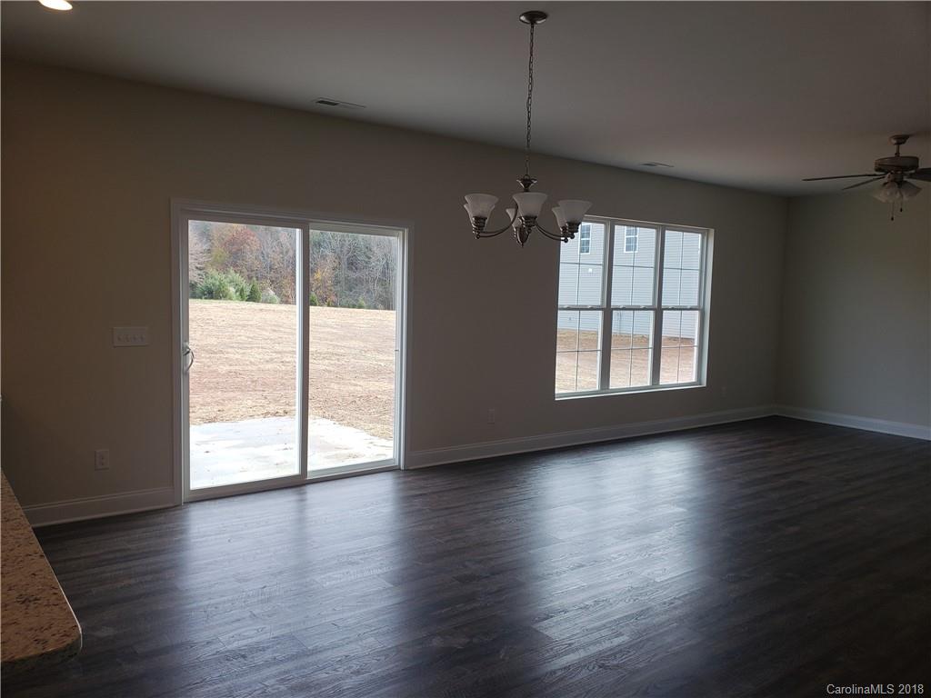 4220 Sincerity Road, Unit 4 Monroe, NC 28110 - Photo 3 of 23 an empty room with wooden floor large windows and chandelier