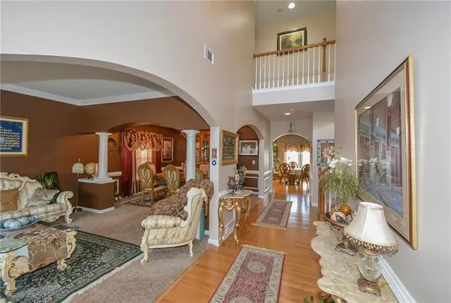a living room with furniture a chandelier and glass door