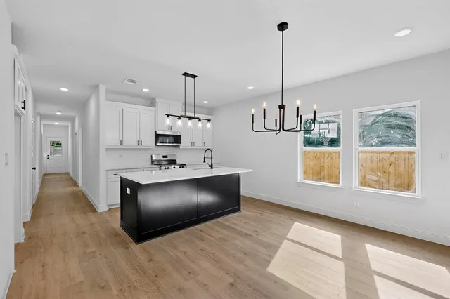 a kitchen with stainless steel appliances granite countertop a stove a sink and a refrigerator