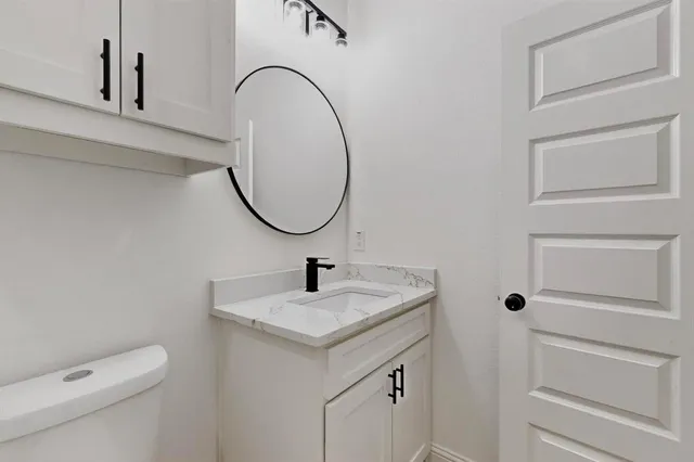 a bathroom with a sink a toilet and a mirror
