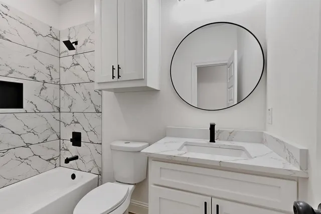 a bathroom with a sink a toilet and a mirror