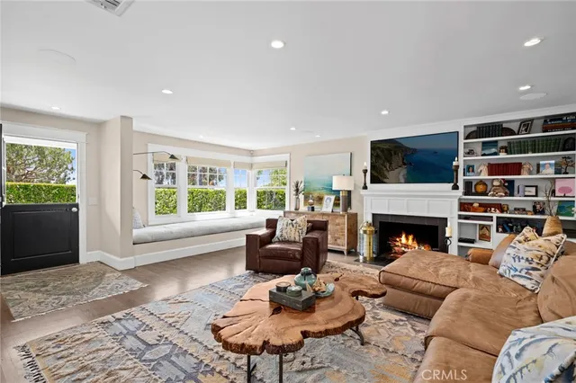 a living room with furniture fireplace and a large window