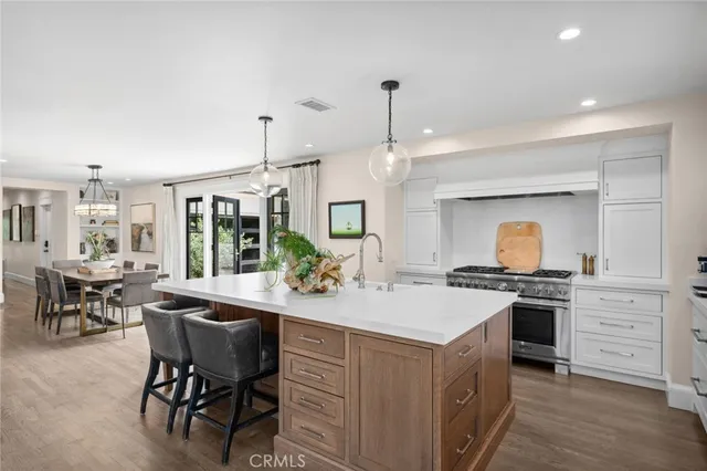 a kitchen with a stove a table and chairs in it