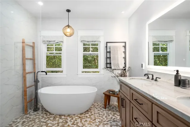 a bathroom with a white tub a window and a shower