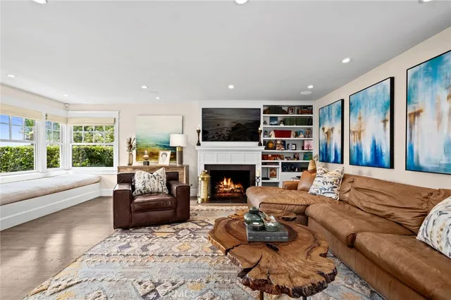 a living room with furniture a fireplace and a large window