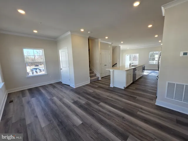 a kitchen with stainless steel appliances a refrigerator a stove top oven with wooden floor