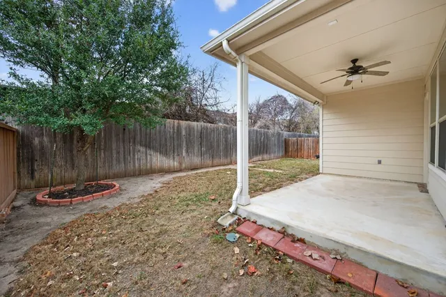 a view of backyard with wooden fence