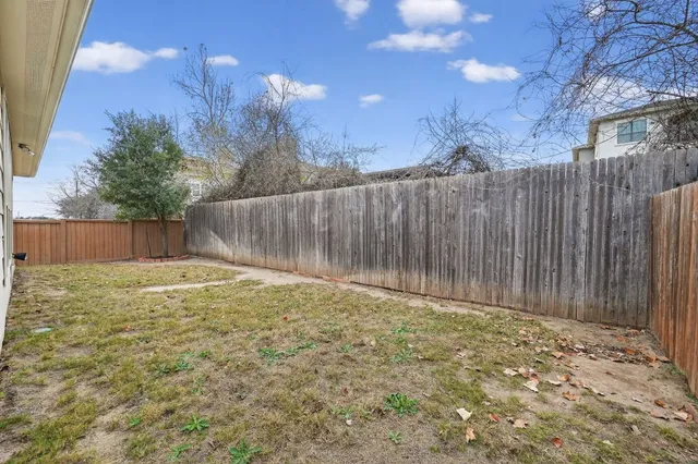 a view of a house with a yard and wooden fence