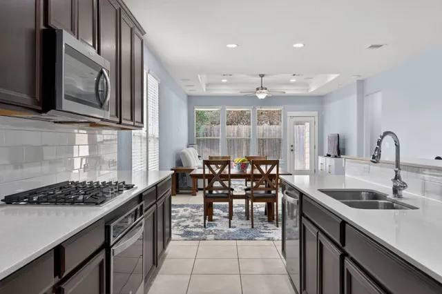 a kitchen with stainless steel appliances granite countertop a sink stove and cabinets
