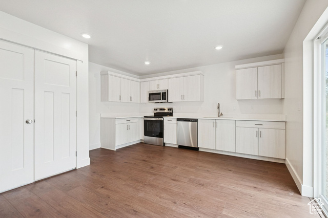 1615 North Angel Street, Unit I Layton, UT 84041 - Photo 18 of 56 Kitchen with stainless steel appliances, light countertops, dark wood-type flooring, white cabinetry, and recessed lighting